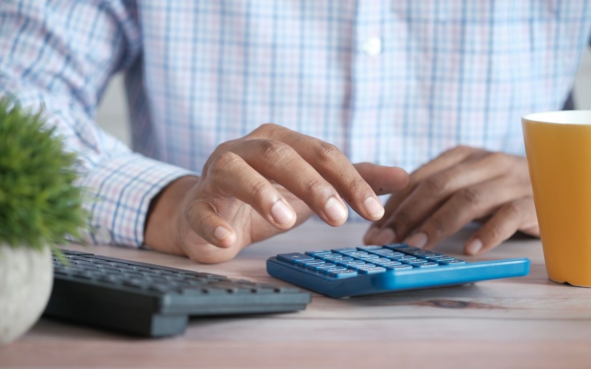 Hands working out numbers on a calculator at a desk